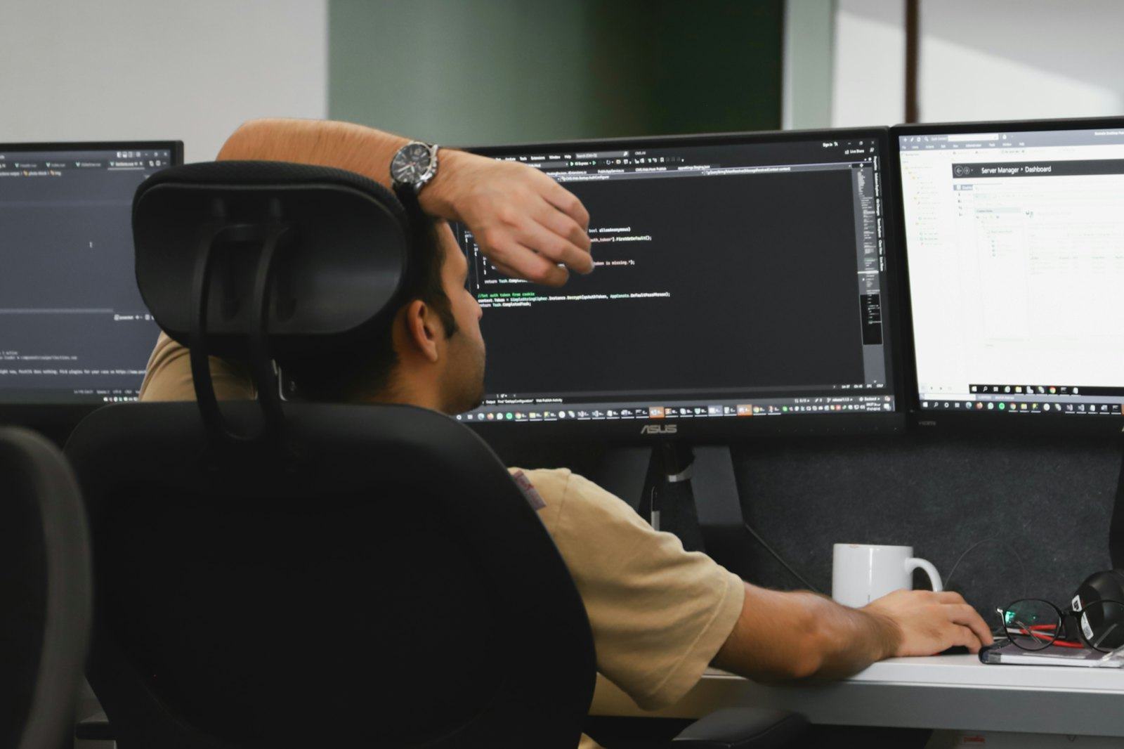 An engineer working at a multi-monitor desk