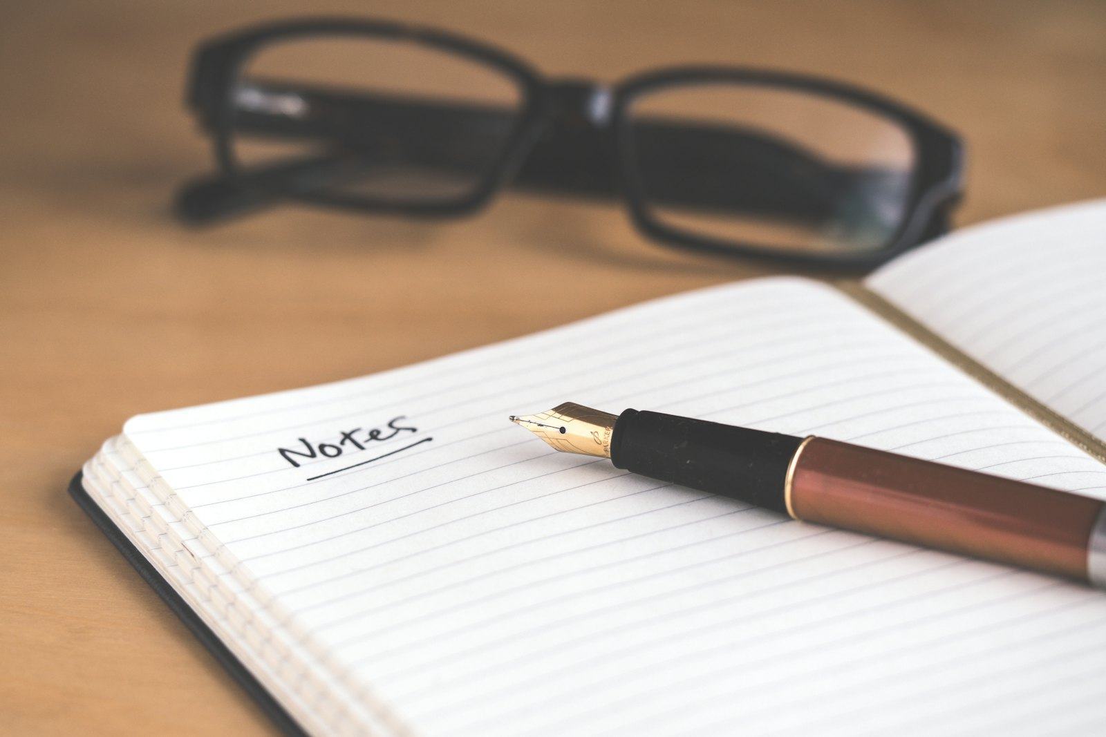 A notebook and pen left open on a desk